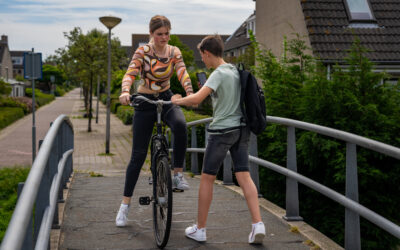 Meisje van 13 op fiets wordt aangesproken door leeftijdsgenoot, situatie die grensoverschrijdend kan voelen – thema uit workshop zelfverdediging voor meiden 11-15 jaar in Velserbroek.